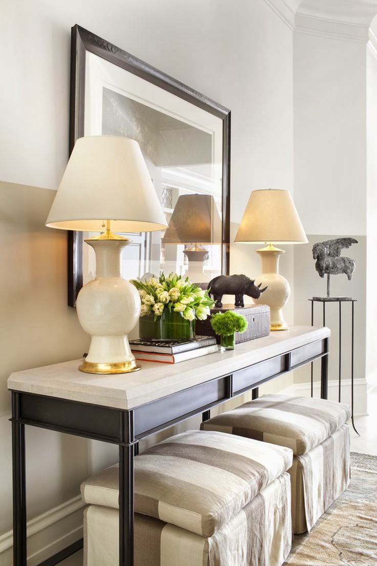 Love this beautiful entryway with gorgeous console table styling and two striped ottomans for seating - holt interiors
