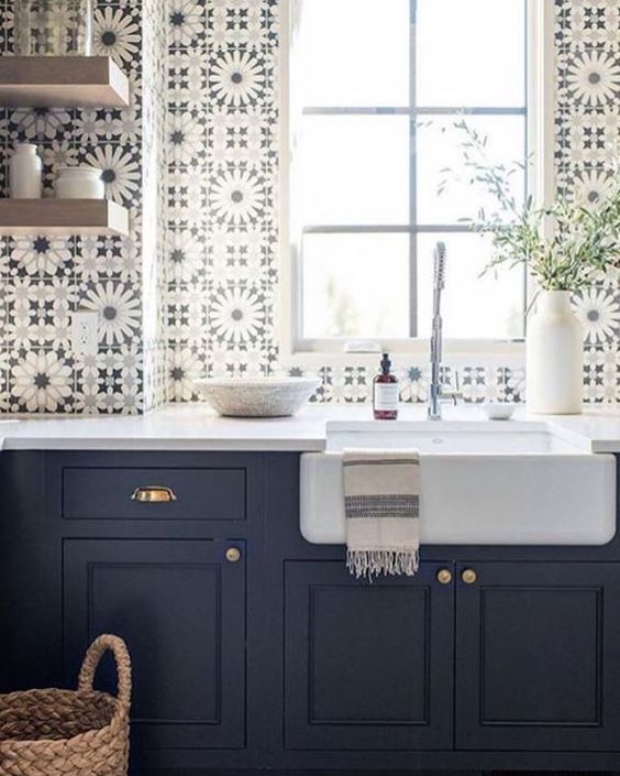 Love this beautiful laundry room with dark blue cabinets, open shelving, a farmhouse sink, and patterned tile backsplash - whittney parkinson interior design