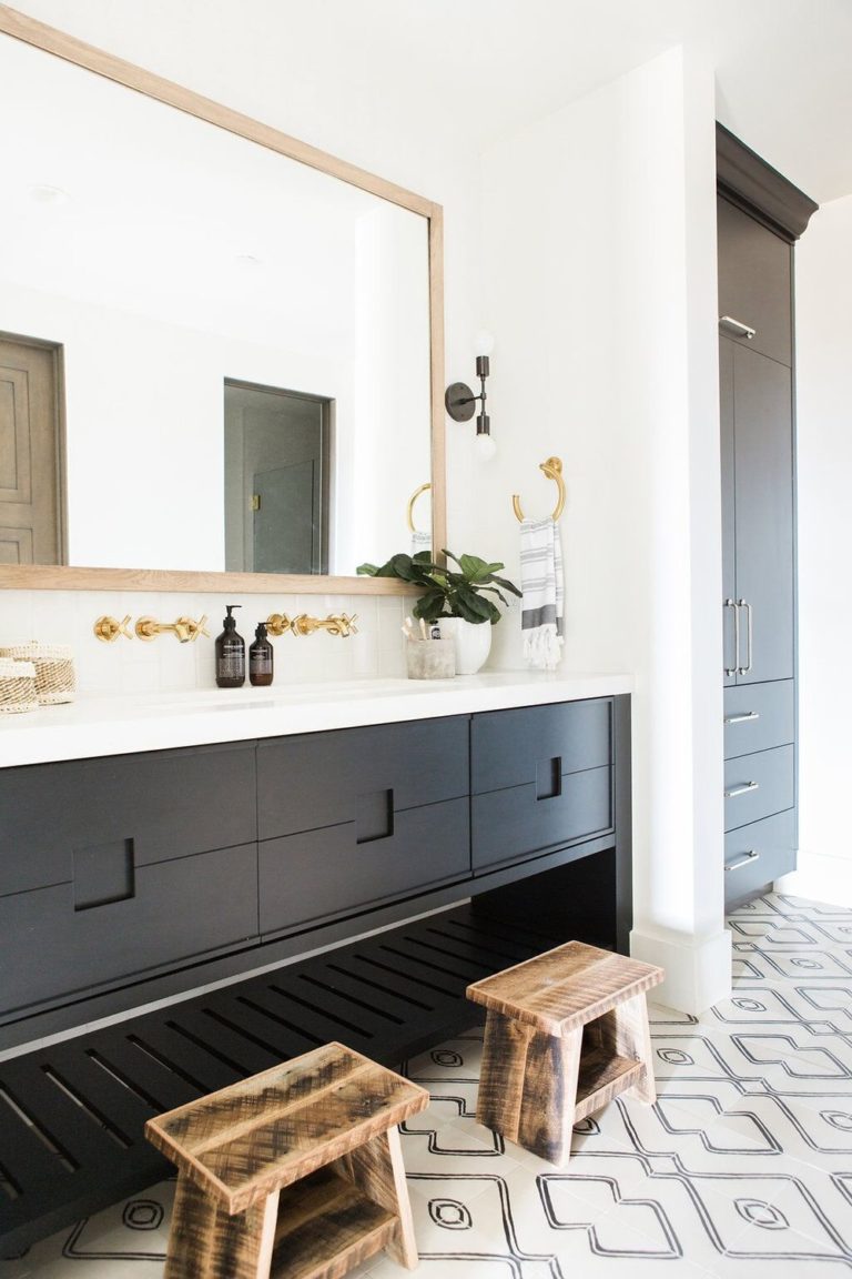 Beautiful modern bathroom design with dark vanity cabinet color and patterned black and white tile floor - Studio McGee