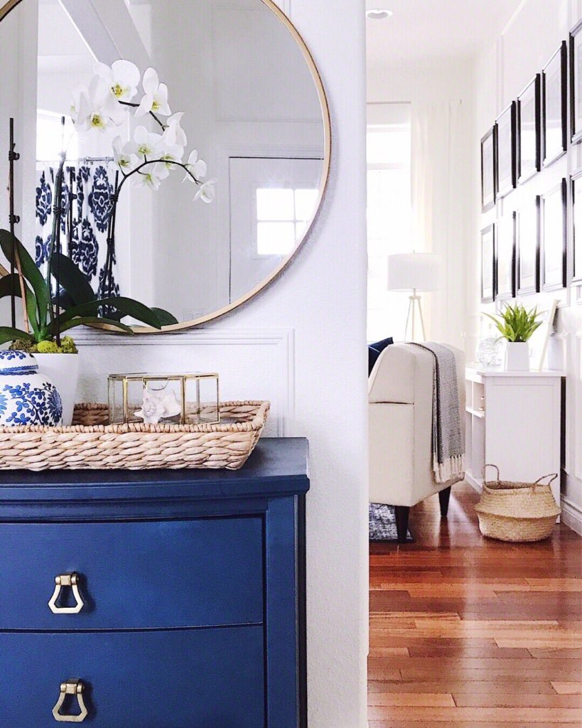 Blue cabinet and round mirror with white phalaenopsis orchid - how to care for orchids after they bloom - jane at home #blue #blueandwhite #bluedecor