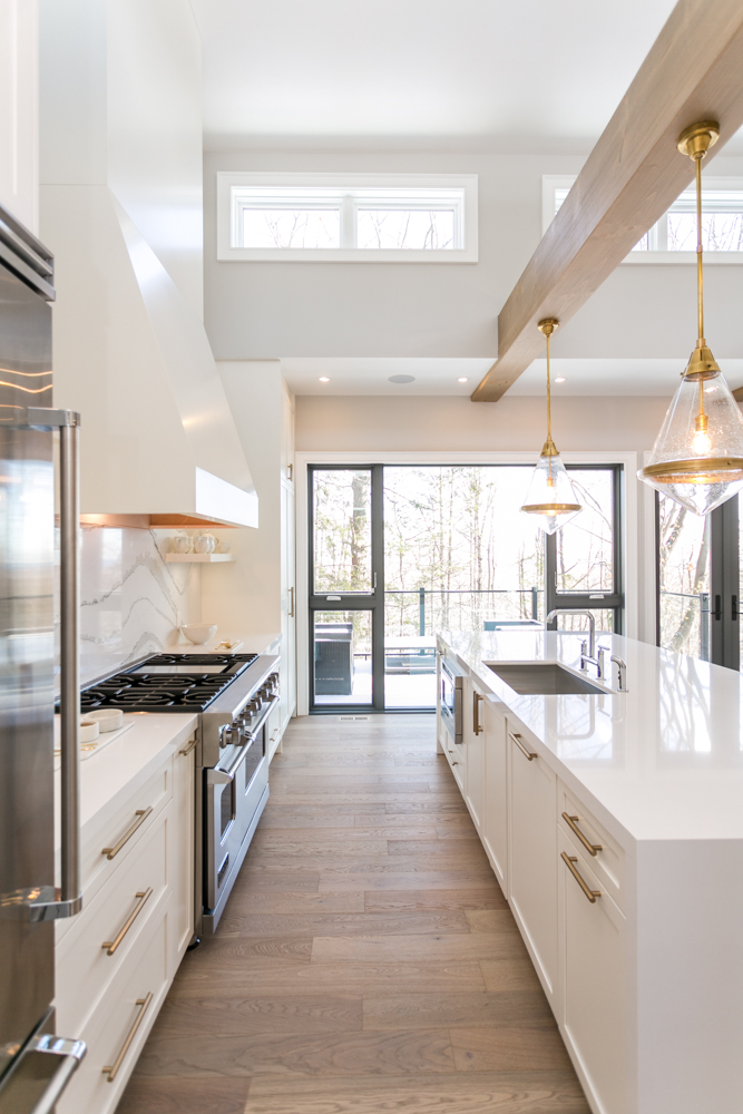 Love this open white kitchen with beams, marble backsplash, modern pendants, and gold hardware - kitchen remodel