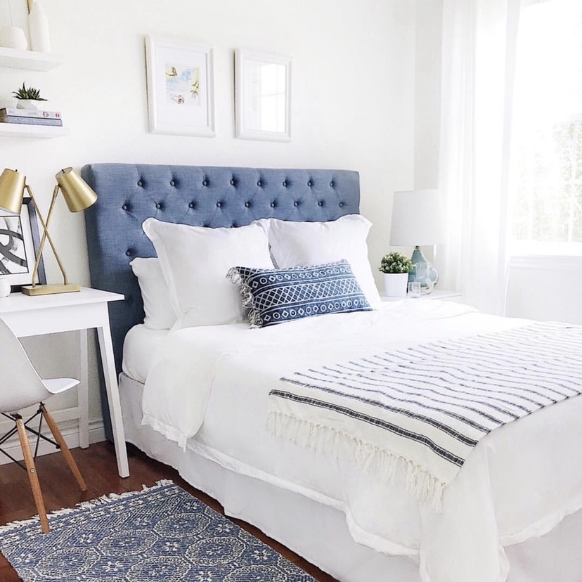 Summer home decor essentials in the guest bedroom - artwork, stripes, pillows, and blue upholstered headboard - jane at home