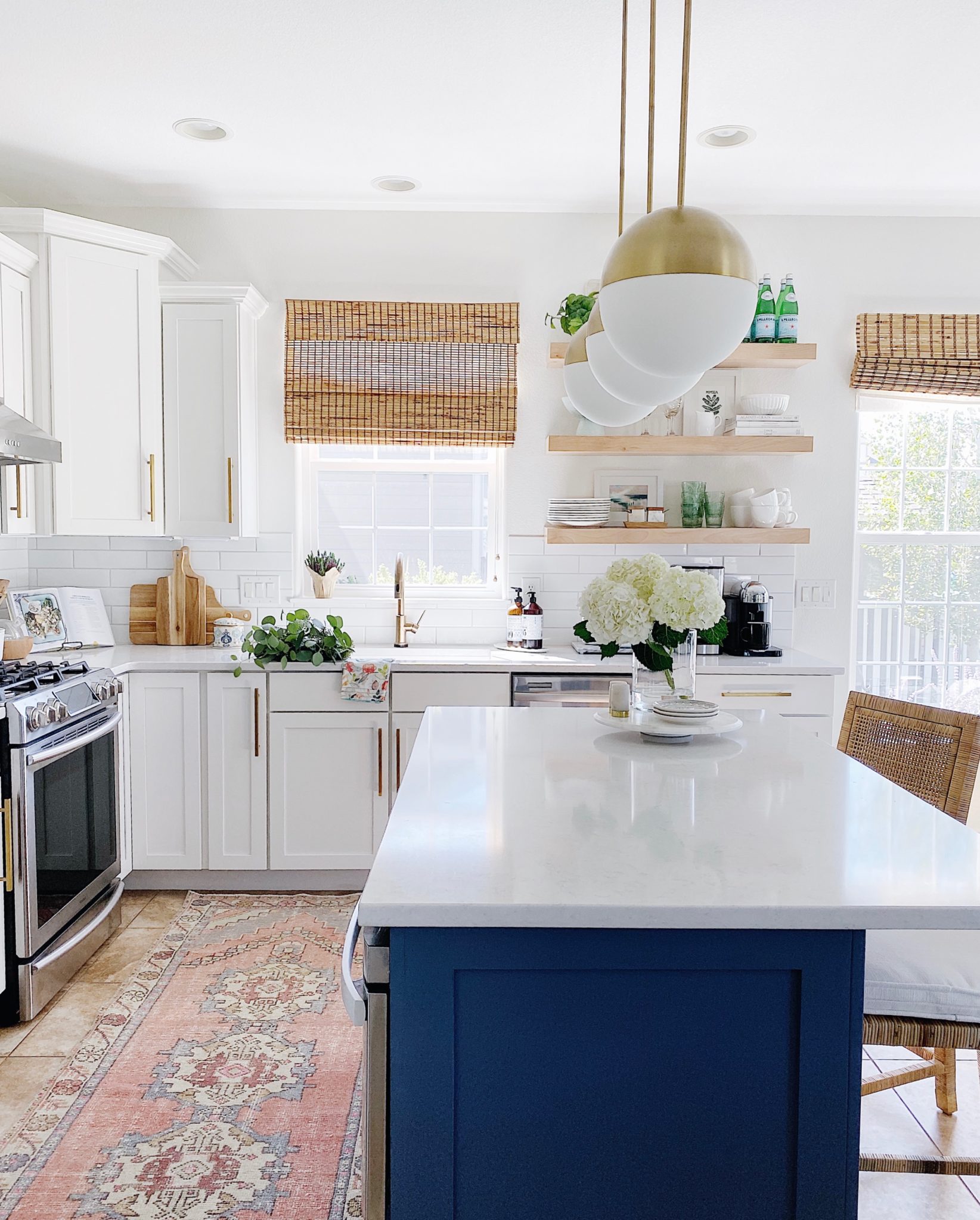 Blue and white kitchen with oushak rug and woven counter stools - jane at home #kitchendesign #bluekitchen #kitchenideas #designstyle