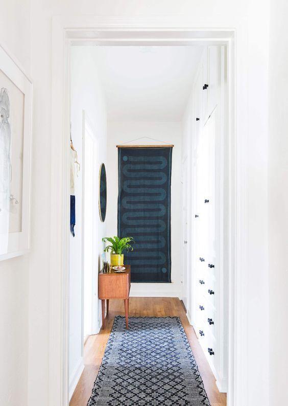 Love this beautiful hallway featuring a dark blue scarf used as a wall hanging and a long indigo runner rug - styled by emily henderson - tessa neustadt