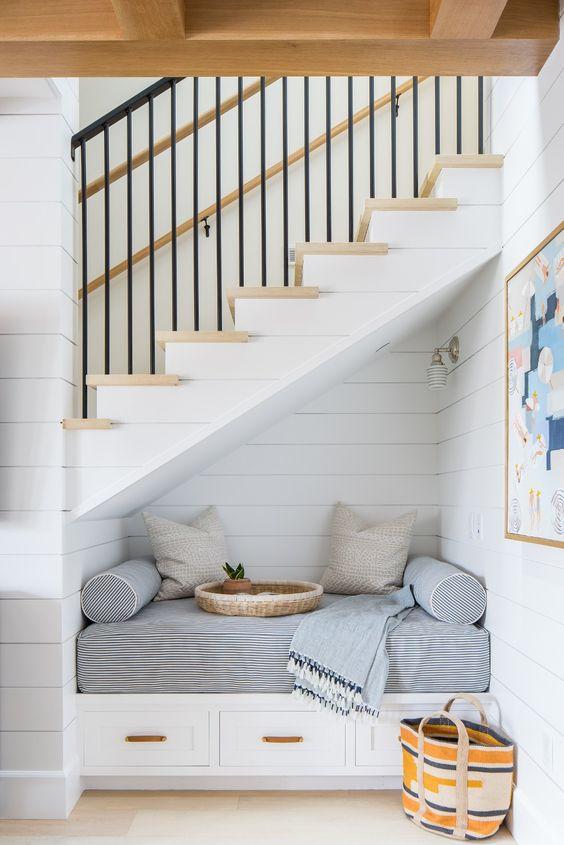 Love this reading nook under the stairs with classic coastal style and a shiplap wall treatment - brooke wagner design