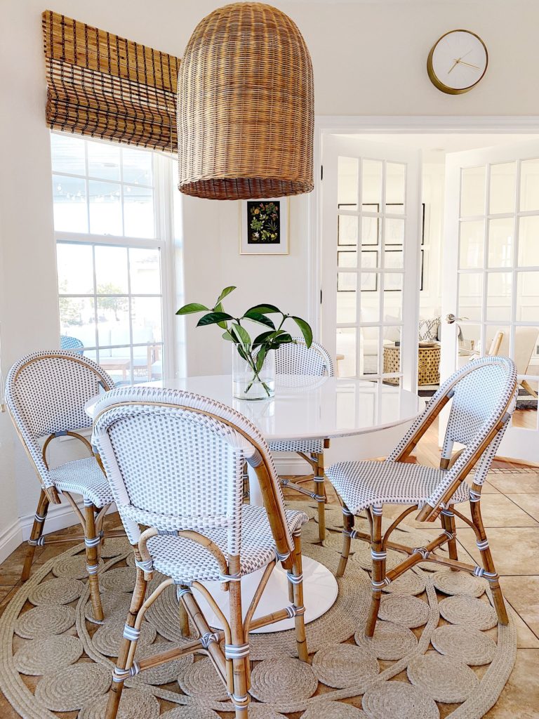 Breakfast nook & kitchen dining area with white tulip table, woven pendant light, and bistro chairs from Serena & Lily - jane at home