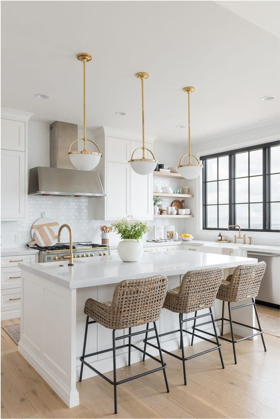 Beautiful white kitchen pendant lighting ideas you'll love - modern coastal kitchen decor with beautiful brass and white pendant lighting over the island and woven counter stools - Christine Andrew - #kitchendesign #kitchenideas #kitchendecor #whitekitchen #modernkitchen #coastalkitchen