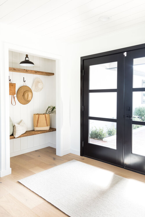 Welcoming entryway, with a pretty spot to hang your hat and remove your shoes, from Pure Salt Interiors - Laguna Beach Project #foyer #entry #mudroom #coastal #farmhouse #modern