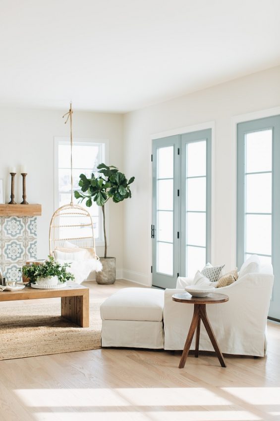 Hanging swing chairs a tiled fireplace surround light coastal decor and French Doors in James River Gray Benjamin Moore