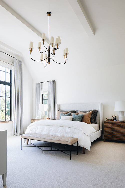 Love this beautiful transitional bedroom design with vaulted ceilings, an upholstered bed, chandelier, and neutral bedding, decor, and furniture - kate marker interiors