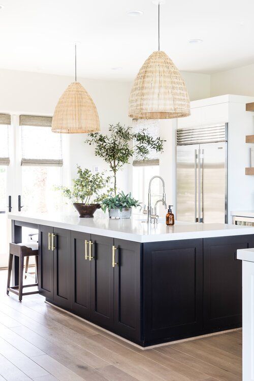 Stunning modern kitchen with black island, white cabinets and beach house style pendant lights over the island