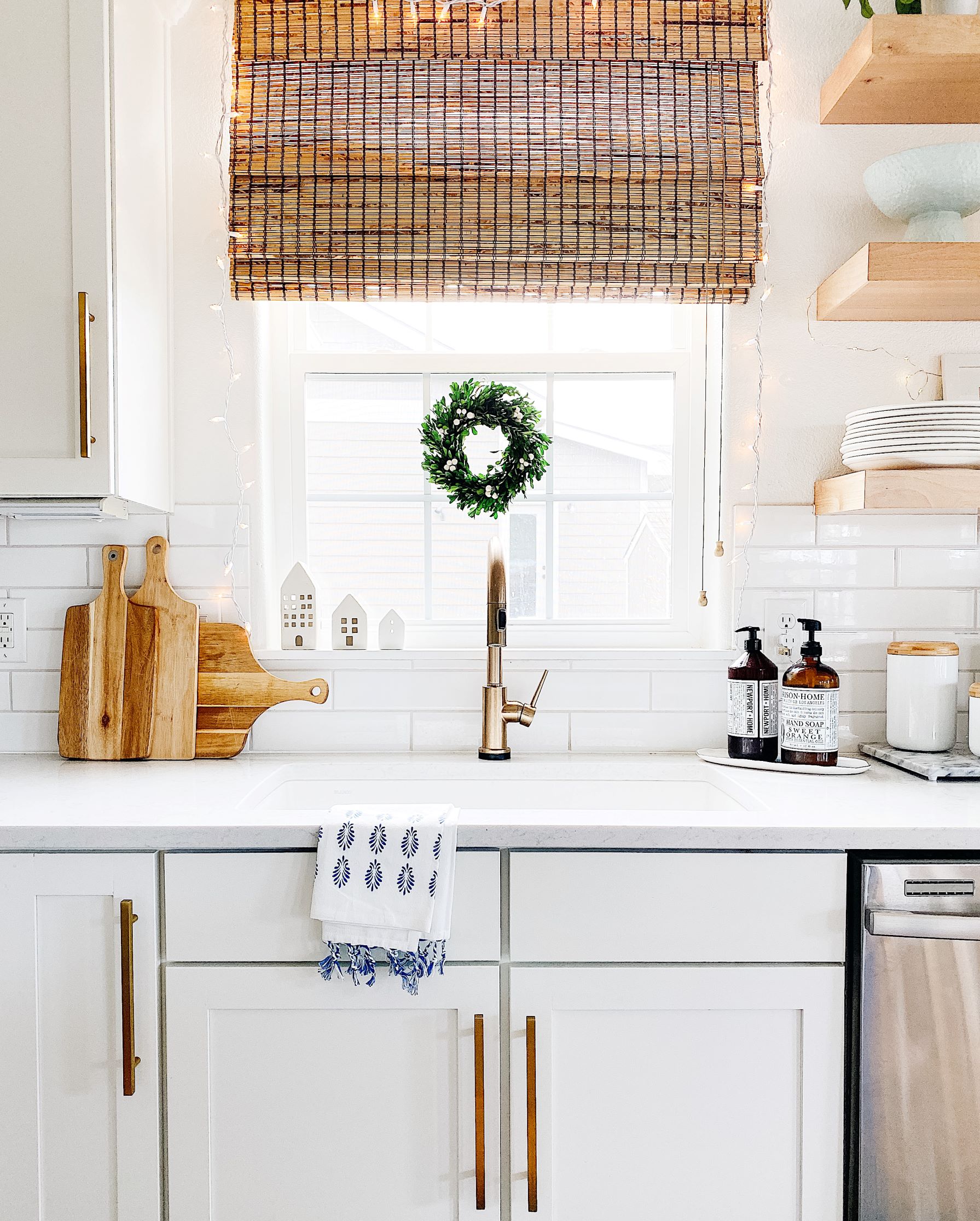 Love adding twinkle lights and Christmas wreaths to the kitchen during the holidays! #christmasdecor #homedecor #home #styling - jane at home