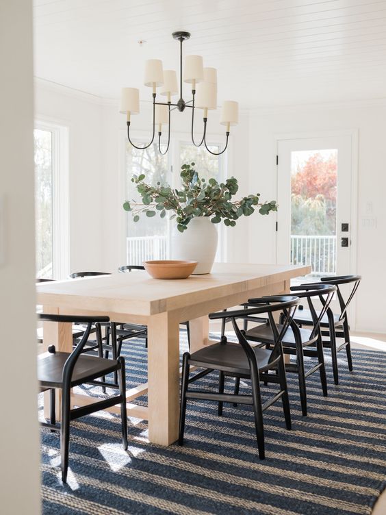 Beautiful dining room with striped rug and black wishbone side chairs