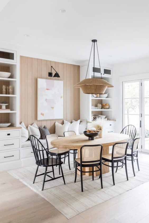 Design and decor trends for 2021: Beautiful dining room with warm tones, woven light fixture, cane chairs, and oval table