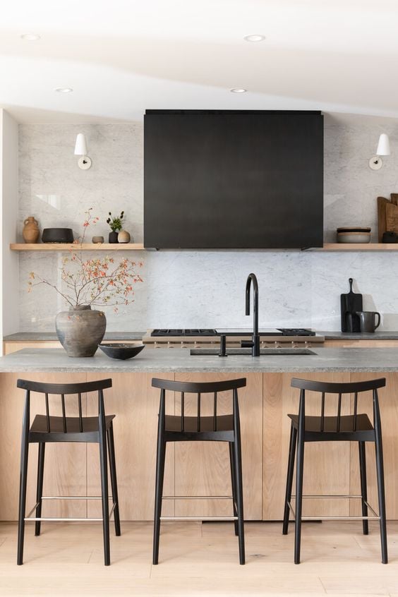 A gorgeous modern farmhouse kitchen with rustic wood island, open shelving and black hood and counter stools from Sophie Burke Design