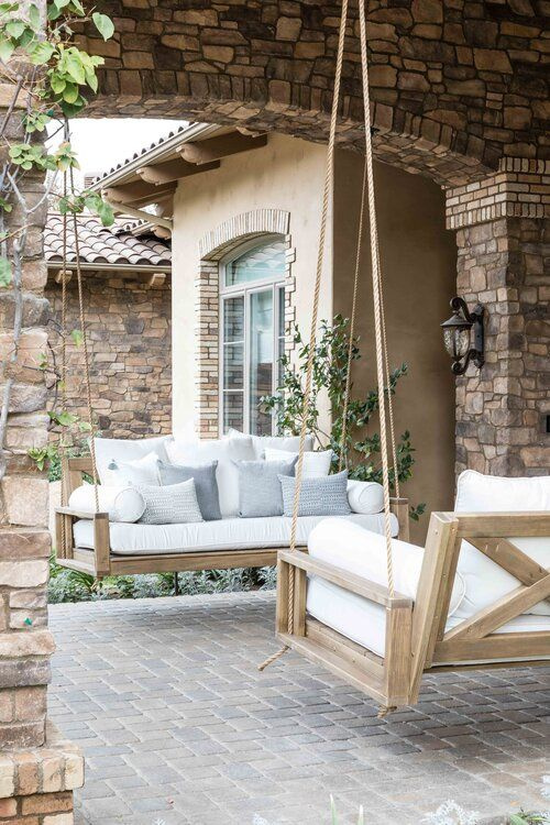 Love this beautiful home entrance with two wooden porch swings 