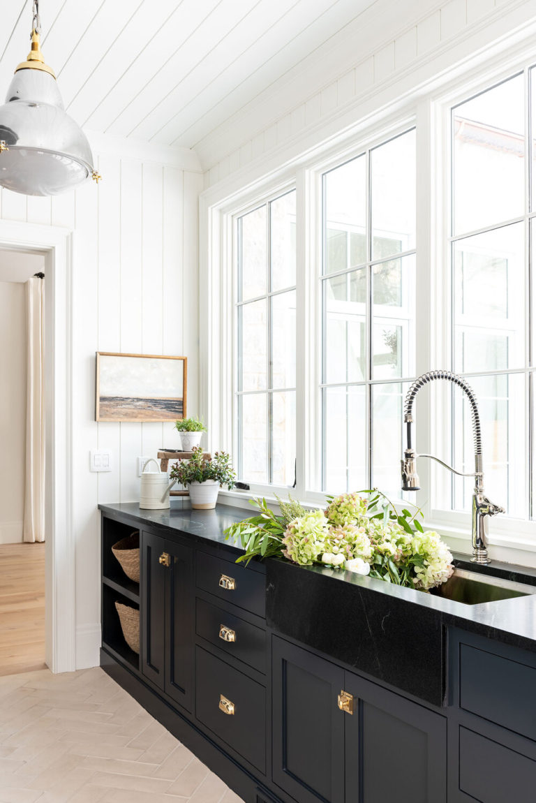 Beautiful details in the mudroom, including mixed metals, black cabinets, herringbone floors and an abundance of natural light