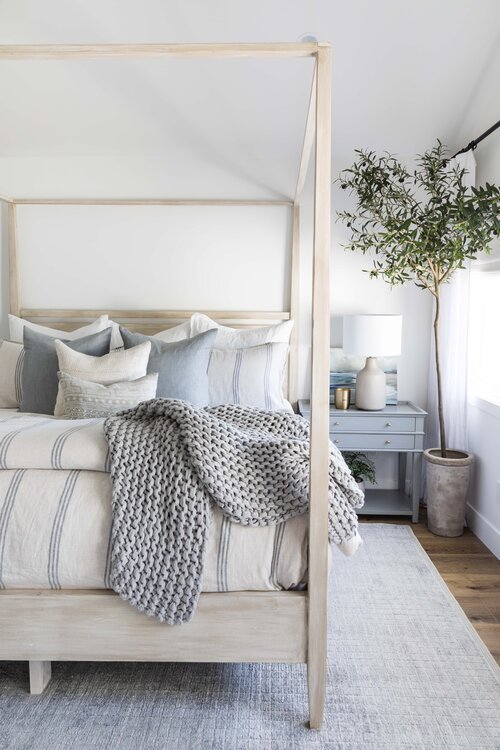 Beautiful bedroom with wood canopy bed and modern coastal accents - Pure Salt Interiors