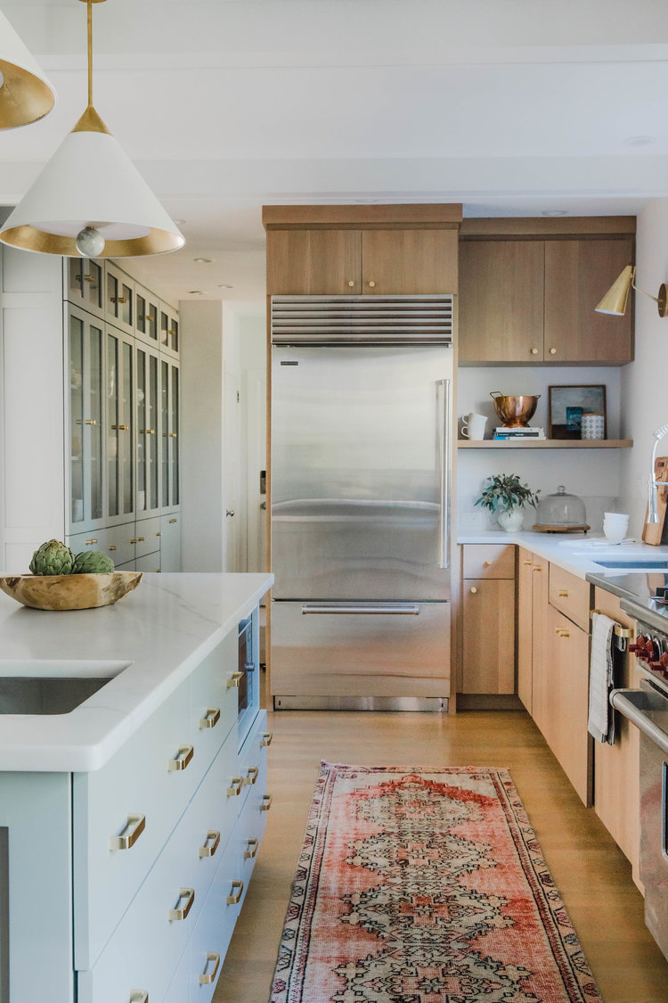 Beautiful modern kitchen with light wood cabinets and light gray green kitchen island - Rehabitat