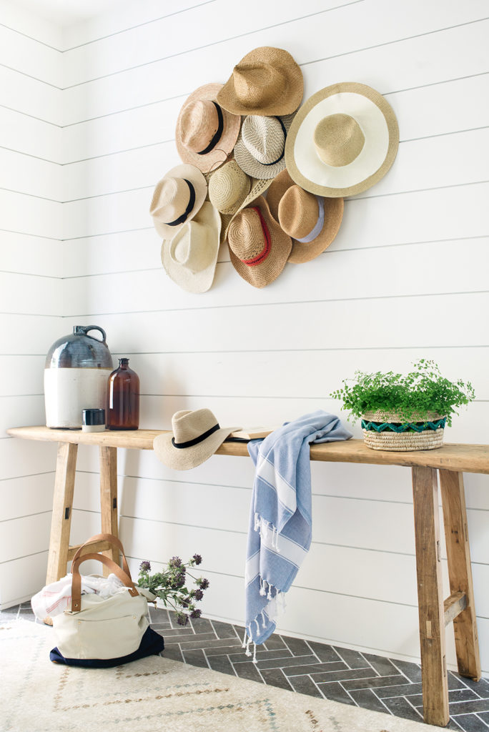 Beautiful boho beach house entryway with shiplap walls and straw hats - Kate Lester