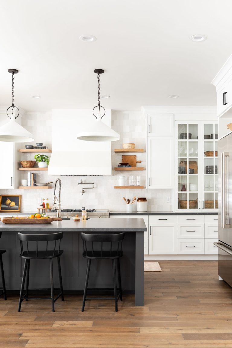 Beautiful black and white transitional kitchen with dark kitchen island and white cabinets 