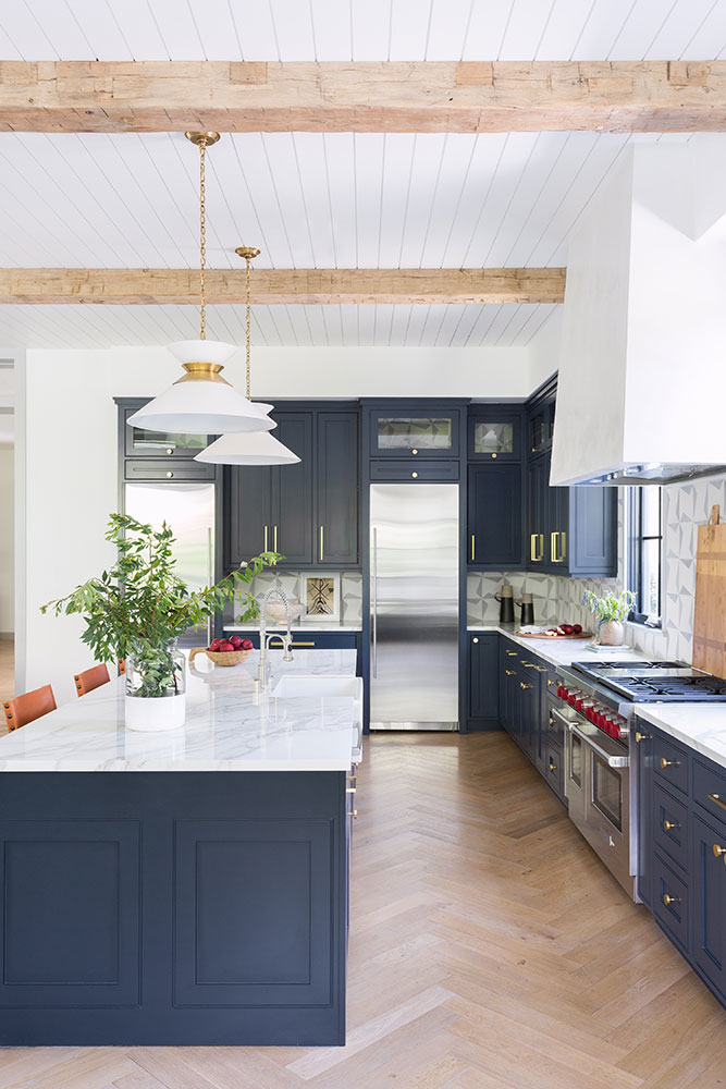 I love the fresh feeling of this beautiful kitchen, with its rich navy cabinets, herringbone wood flooring, shiplap ceiling, and rustic wood beams. kitchen remodel - kitchen design - kitchen decor - kitchen ideas - blue kitchen - navy kitchen