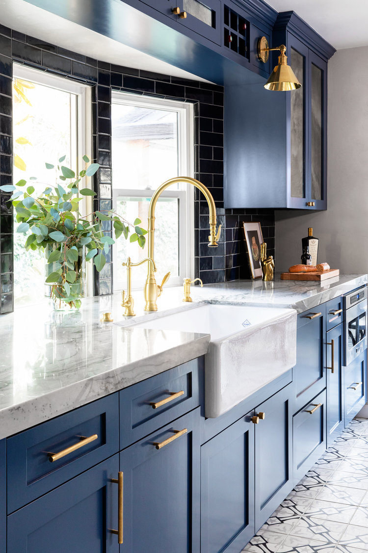 Stunning blue kitchen with brass sconces and black tile backsplash - anne rae design