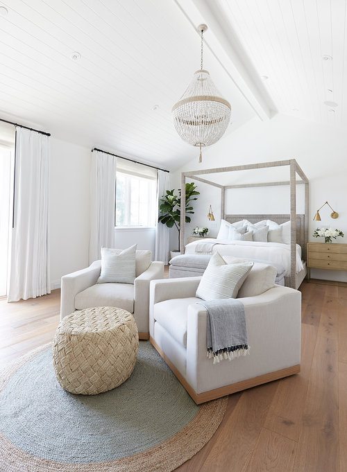 Love this luxurious modern coastal master bedroom with a four-poster canopy bed, beaded chandelier, and seating area with two swivel chairs - bedroom ideas - bedroom decor - coastal bedroom - coastal decor - coastal grandmother - pure salt interiors