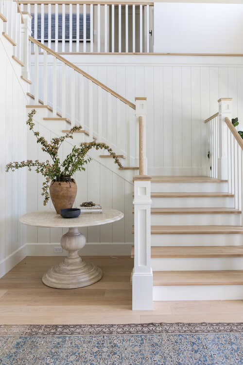 Love this beautiful entryway and staircase idea with a round wood table and white and wood stairs - entry ideas - foyer - entryway ideas - stairway ideas