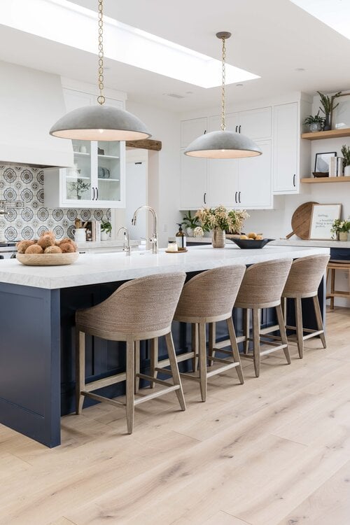 Love this gorgeous modern kitchen design with woven counter stools and black pendant lights over the island