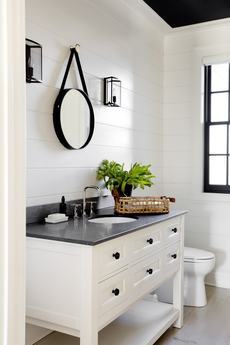 Beautiful powder bathroom with white vanity and black countertop - tamara magel