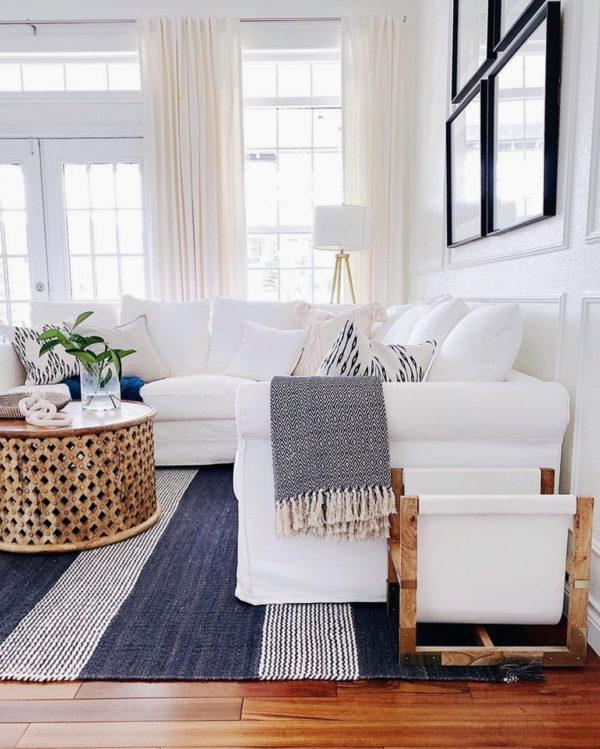 Neutral living room decor with striped rug, slipcovered sectional sofa, round coffee table and neutral pillows with a modern coastal touch - jane at home #decor #design #style #ideas