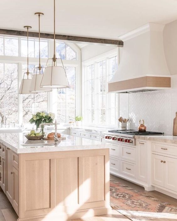 Love this beautiful kitchen design with a light wood kitchen island, white cabinets, and white and gold pendant lights - quiet luxury - ali henry
