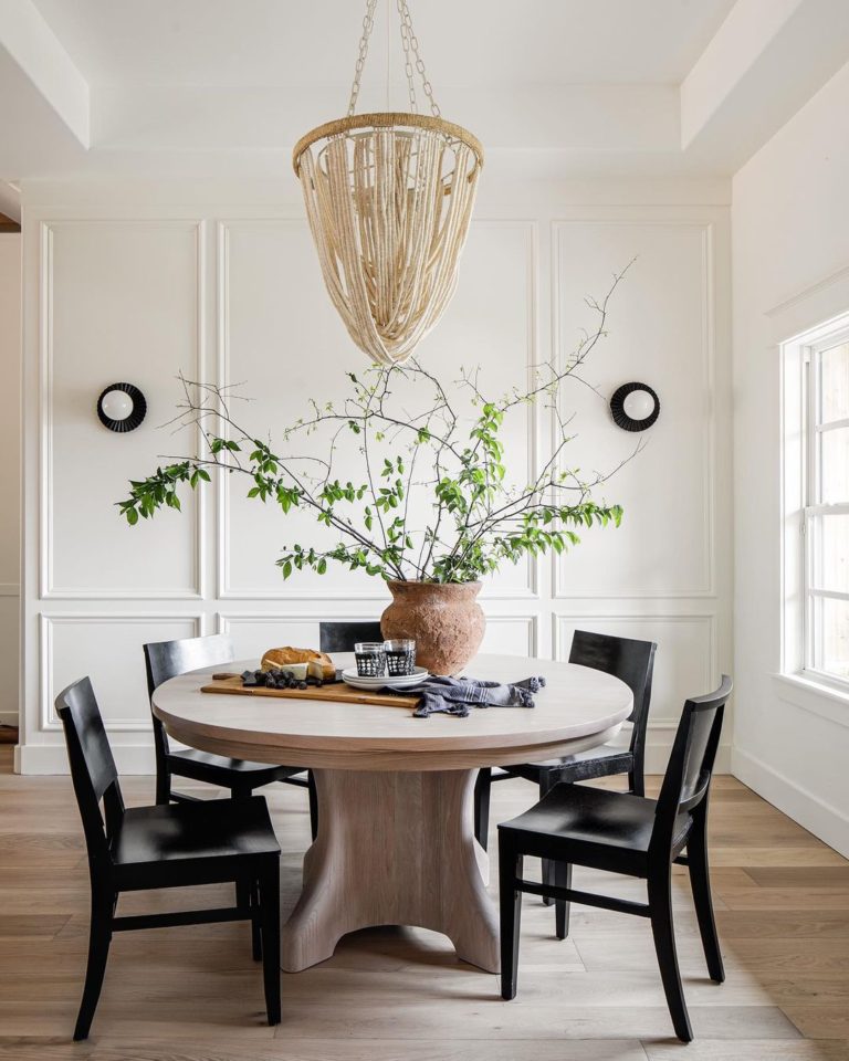 Here’s how to bring a modern look to the dining room: fresh branches popped in a rustic terra cotta vase, a warm wood charcuterie board (complete with linen napkins), a natural rope chandelier, and touches of black.