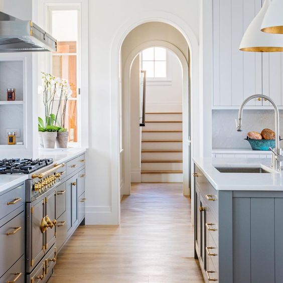 Gorgeous kitchen design with blue island and arched doorway - Marshall Erb Design