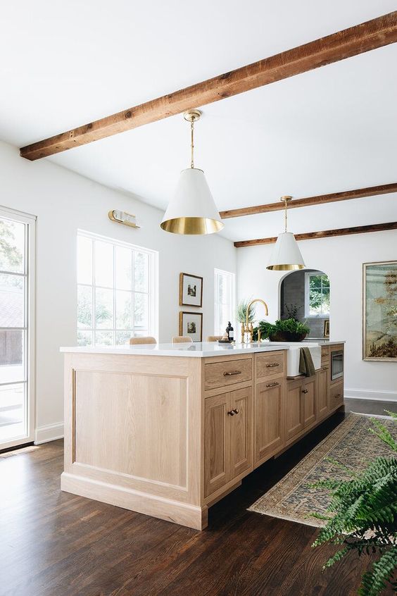 Love this beautiful modern kitchen design with a light oak wood island, vintage rug, wood beams, and white and brass cone pendant lights - kitchen decor - kitchen lighting - kitchen island ideas - jean stoffer