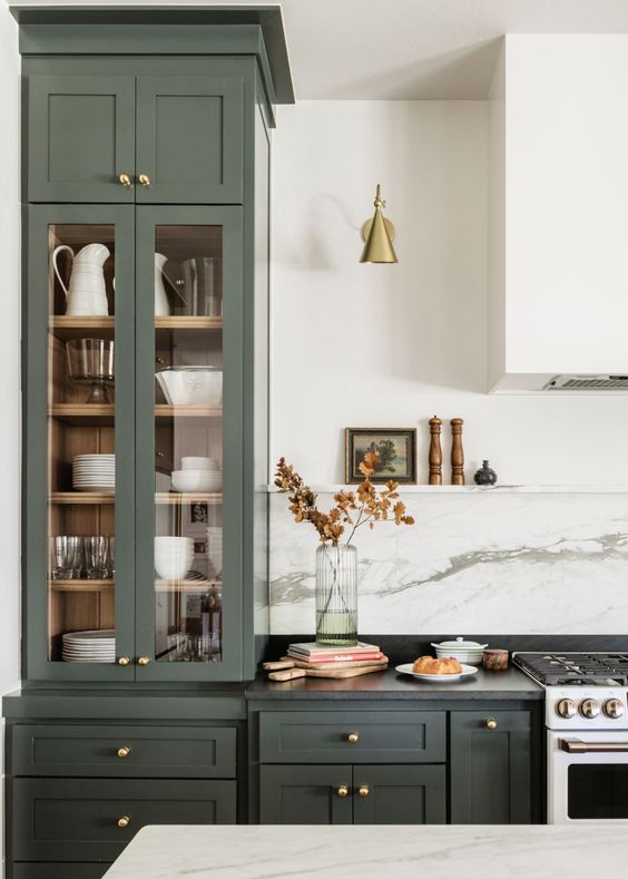 Love this beautiful kitchen design with dark green cabinets, marble backsplash, brass lighting and custom range hood - kelsey leigh design