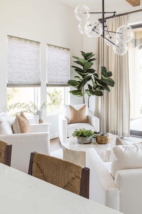 Love this beautiful living room with four white swivel chairs around a coffee table and neutral decor and furniture - fall decor -- living room decor - living room furniture - living room table - coastal decor 