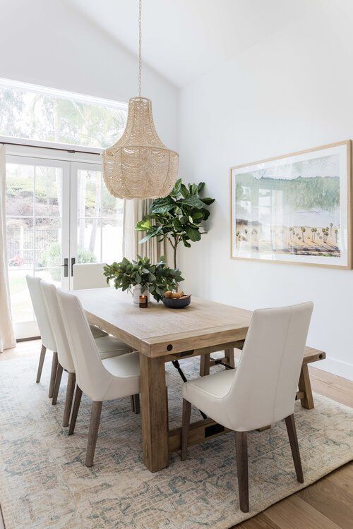 Love this beautiful dining room with a beaded chandelier, wood dining table, and modern coastal artwork - dining room ideas - dining room lighting - dining room decor - dining room furniture - modern coastal style - coastal decor - pure salt interiors