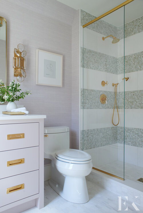A beautiful small bathroom design with striped tile in the shower and brass gold accents - elizabeth krueger design - powder bath - small bathrooms - guest bathroom ideas - bathroom remodel