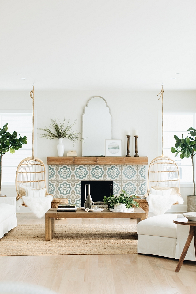 Love this light and airy living room design with two hanging chairs next to the fireplace, along with white slipcovered furniture and neutral decor - living room ideas - coastal interiors - living room decorating ideas - modern coastal style
