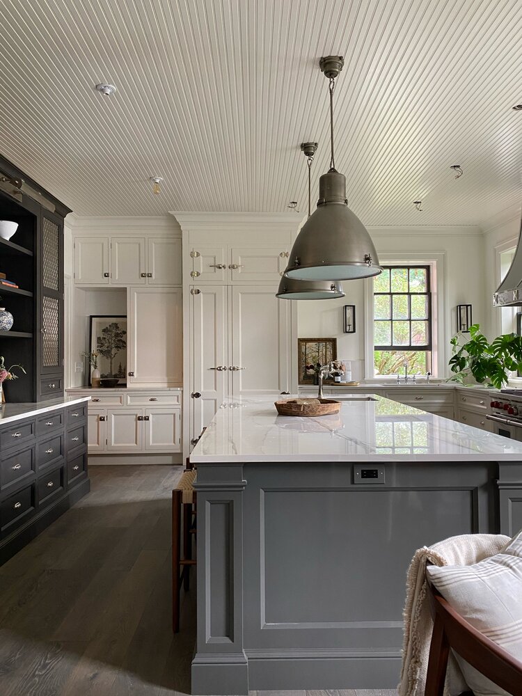 How to add a touch of Nancy Meyers style to your kitchen and home - beautiful kitchen design with gray and white cabinets - black pendant lights and charming decor - jean stoffer