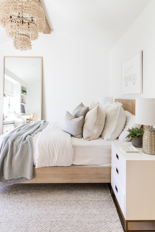 Beautiful feminine bedroom with layered bedding and boho decor - pure salt