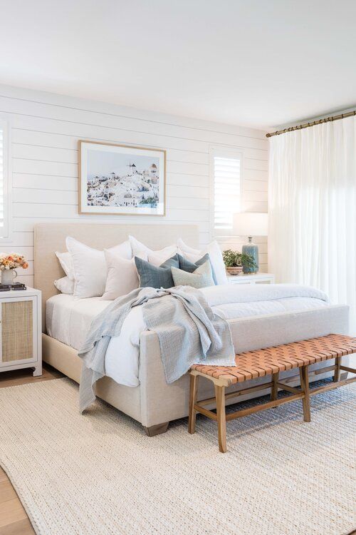 Love this light and airy modern bedroom design with neutral bedding and furniture, a shiplap feature wall, and a woven bench at the end of the bed - master bedroom ideas - modern bedroom - coastal bedroom ideas 