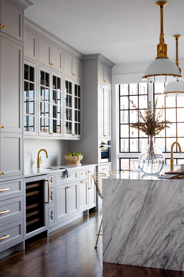 Love this beautiful kitchen with its waterfall marble island, gray kitchen cabinets, and brass faucets, pulls, and pendant lights - kitchen remodel - kitchen ideas - kitchen decor