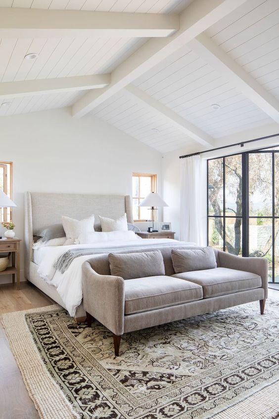 Love this beautiful master bedroom design with a sofa at the end of the bed and light neutral decor and furniture - studio mcgee