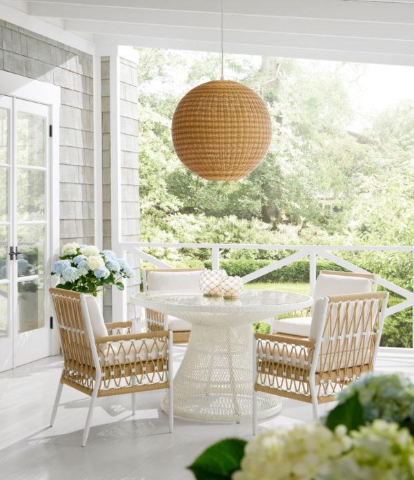 Beautiful covered patio dining area with Serena & Lily outdoor furniture, lighting and decor