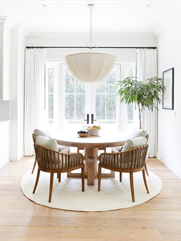 Love this beautiful modern dining area with a woven chandelier, round wood dining table, and natural woven dining chairs - dining room ideas - dining room furniture - dining room lighting ideas - pure salt interiors