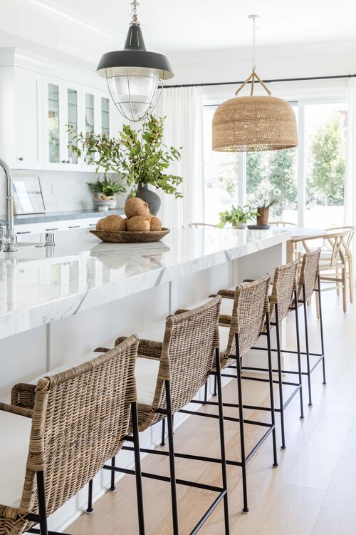 Love this beautiful kitchen design with a long island, white cabinets, woven counter stools and a large woven pendant light in the breakfast nook - kitchen ideas - kitchen decor - white kitchen cabinets - pure salt interior design