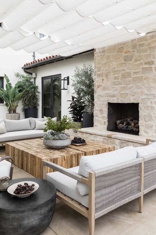 Love this beautiful covered patio and outdoor sitting and lounging area with a stone fireplace - patio ideas - covered patio design - modern coastal style - pure salt